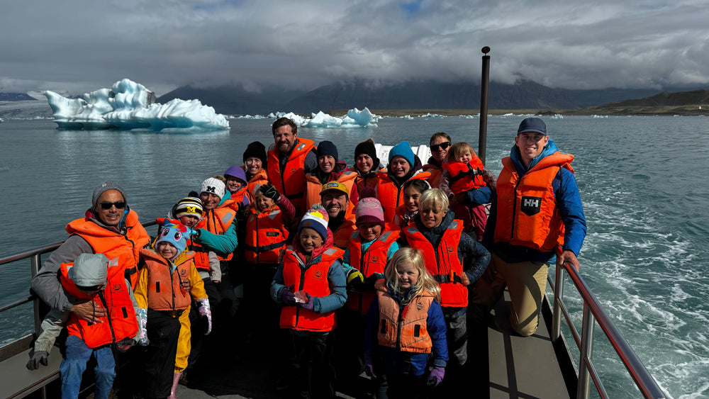 Group of people on a boat trip with icebergs in the background